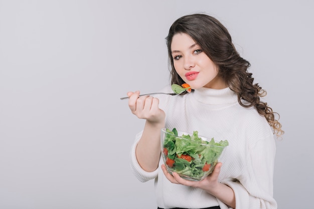 Mujer joven tomando un plato saludable