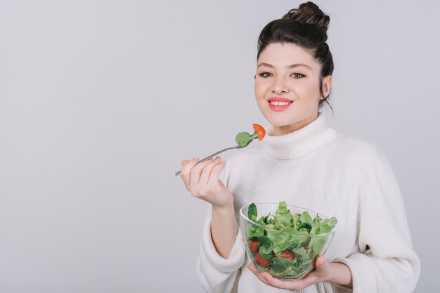 Mujer joven tomando un plato saludable