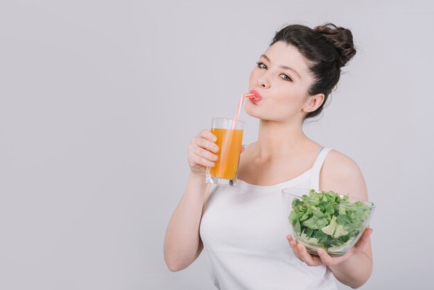 Mujer joven tomando un plato saludable