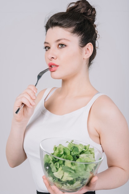 Mujer joven tomando un plato saludable