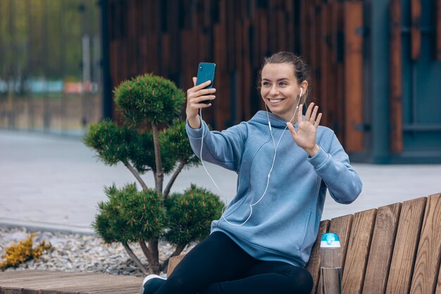 Mujer joven tomando selfie desde arriba en el parque