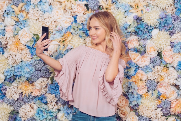 Mujer joven tomando selfie con smartphone