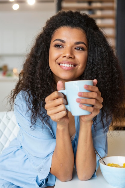 Foto gratuita mujer joven tomando una taza de café