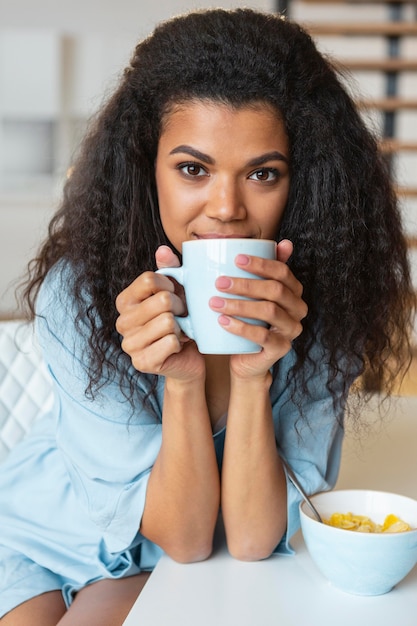 Foto gratuita mujer joven tomando una taza de café