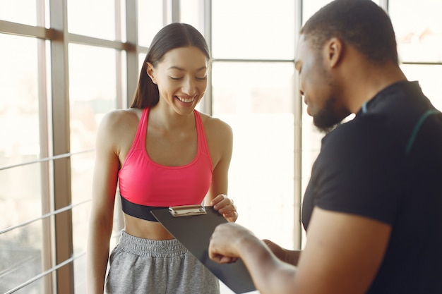 Foto gratuita mujer joven en un top rosa de pie con un entrenador