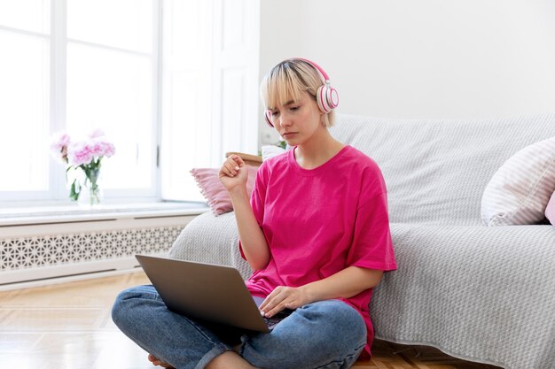 Mujer joven trabajando desde casa en su computadora portátil