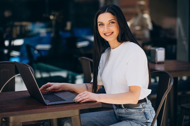 Mujer joven trabajando en un portátil en un café