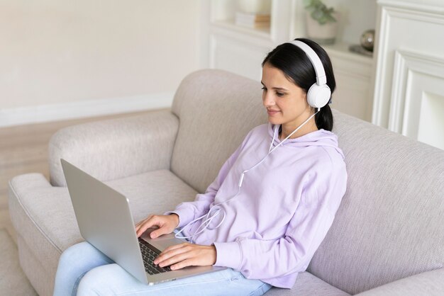 Mujer joven trabajando en su computadora portátil en casa