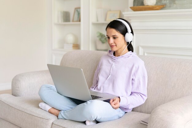 Mujer joven trabajando en su computadora portátil en casa