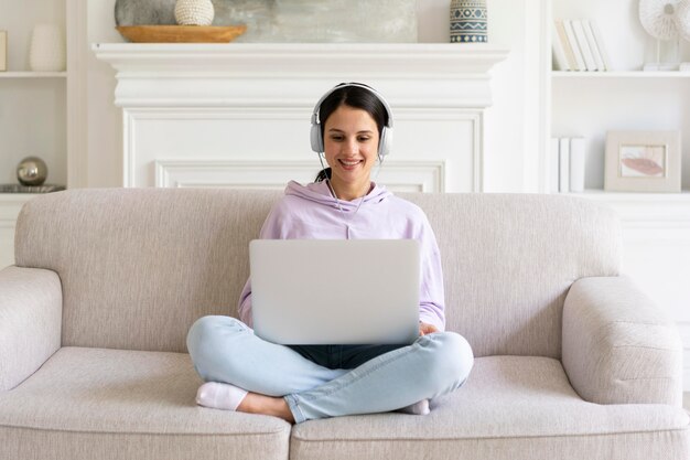 Mujer joven trabajando en su computadora portátil en casa