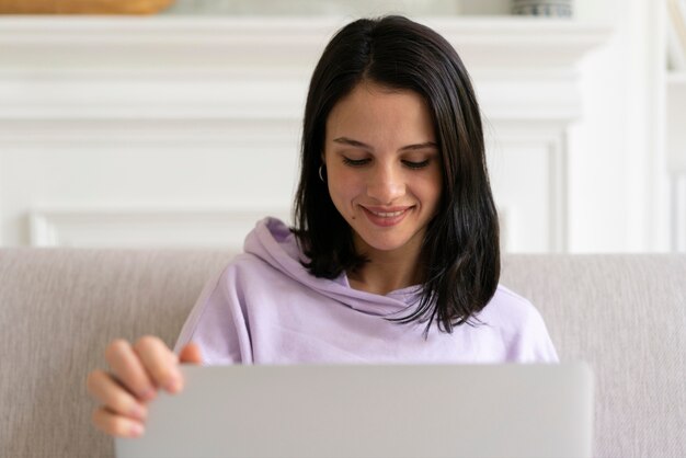 Mujer joven trabajando en su computadora portátil en casa