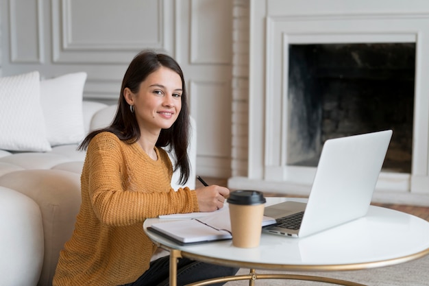 Foto gratuita mujer joven trabajando en su computadora portátil