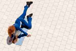 Foto gratuita mujer joven en traje azul posando con espejo en el suelo