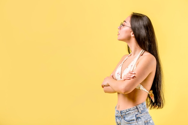 Mujer joven en traje de baño mirando a otro lado