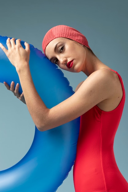 Foto gratuita mujer joven con traje de baño rojo y un anillo de natación