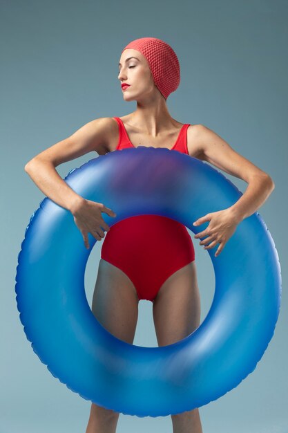 Mujer joven con traje de baño rojo y un anillo de natación