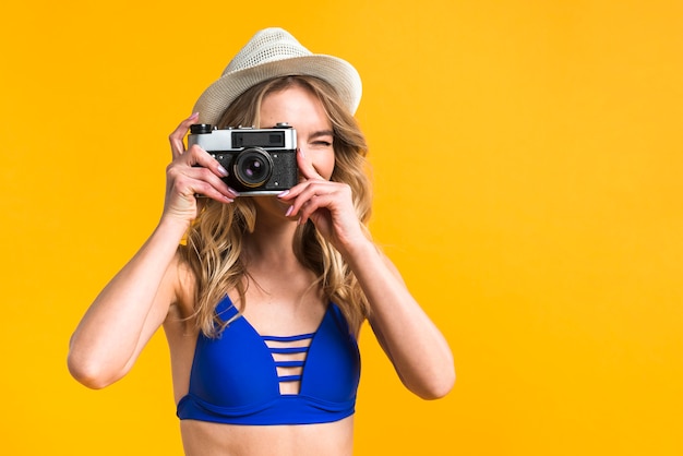 Mujer joven en traje de baño tomando foto