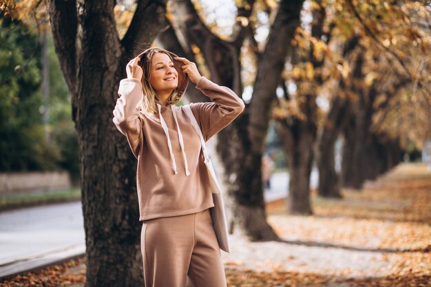 Mujer joven en traje beige afuera en un parque de otoño