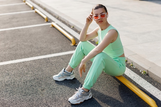 mujer joven en traje casual usando auriculares inalámbricos al aire libre