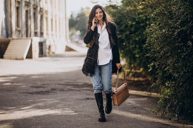 Foto gratuita mujer joven en traje de moda caminando en el parque