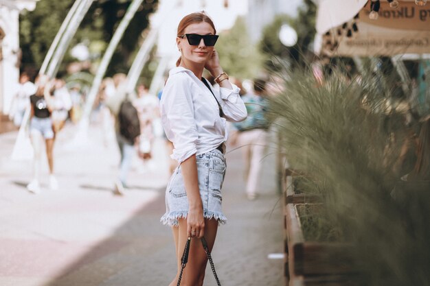 Mujer joven en traje de verano en la ciudad