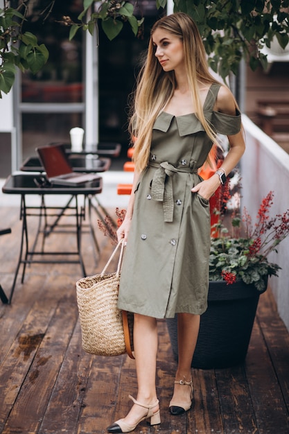 Mujer joven en traje de verano fuera de cafe