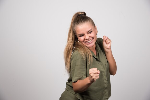 Mujer joven en traje verde sintiéndose feliz.