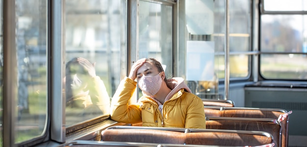 Una mujer joven en un transporte público vacío durante la pandemia.