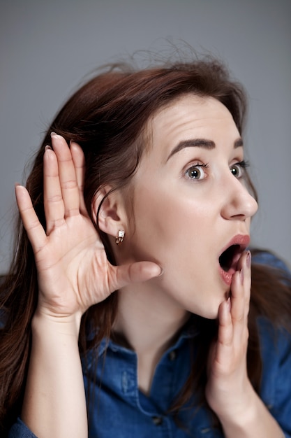 Mujer joven tratando de escuchar algo