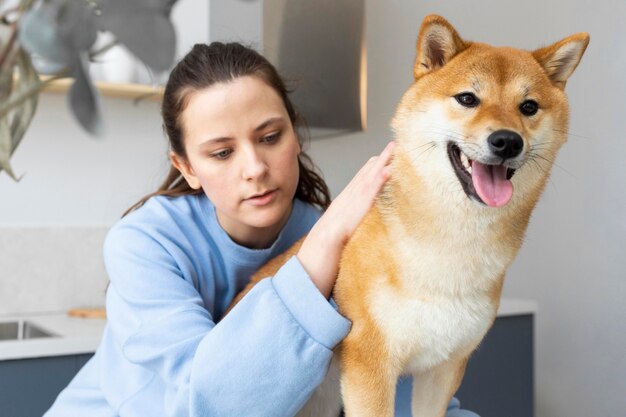 Mujer joven tratando de trabajar mientras su perro la distrae