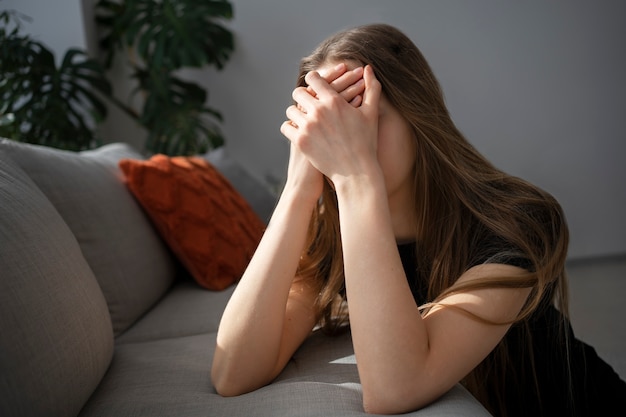 Mujer joven y triste en casa.