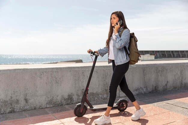 Mujer joven, utilizar, un, scooter, aire libre