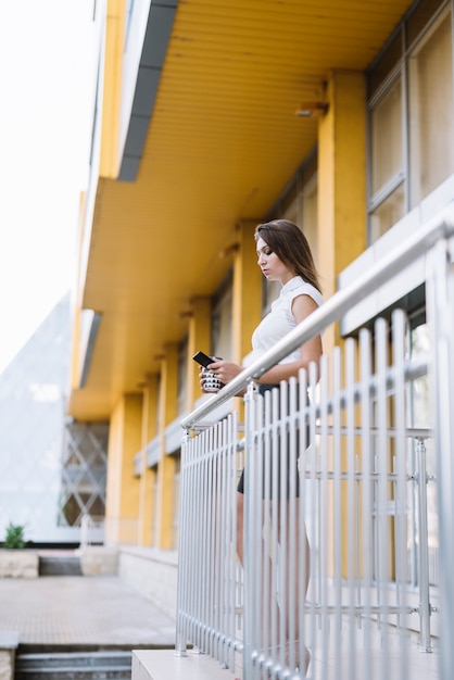 Mujer joven, utilizar, smartphone, posición, en, balcón