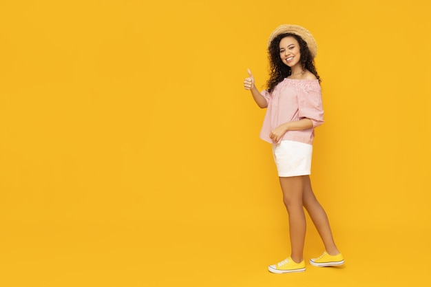 Mujer joven en verano casual vistiendo sobre fondo amarillo