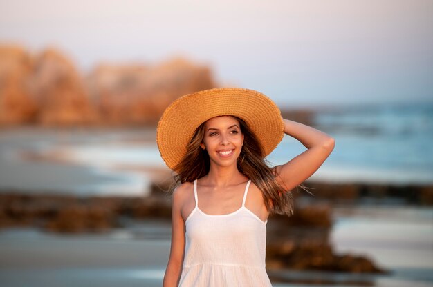 Mujer joven con un vestido blanco junto al mar