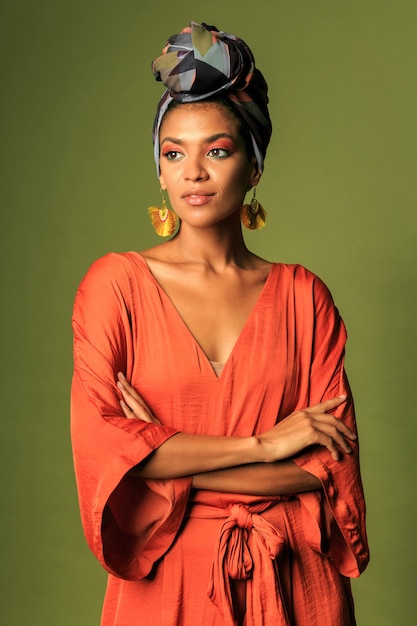 Mujer joven con vestido naranja con turbante y joyería étnica