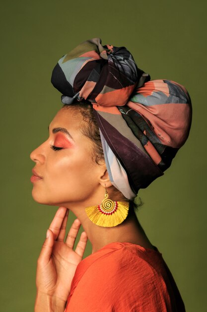 Mujer joven con vestido naranja con turbante y joyería étnica