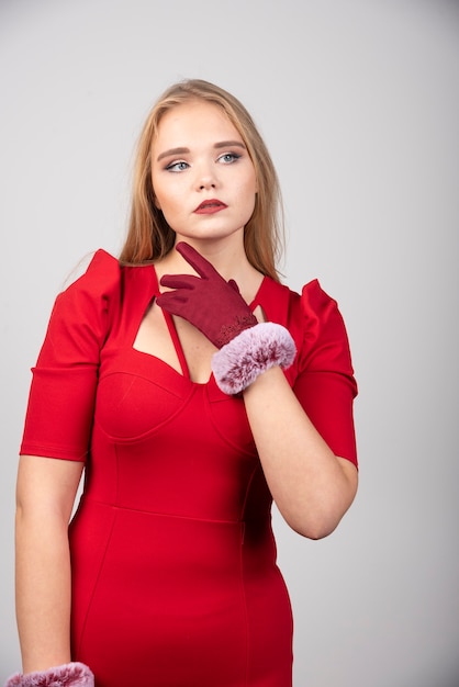 Foto gratuita mujer joven en vestido rojo mirando en algún lugar.