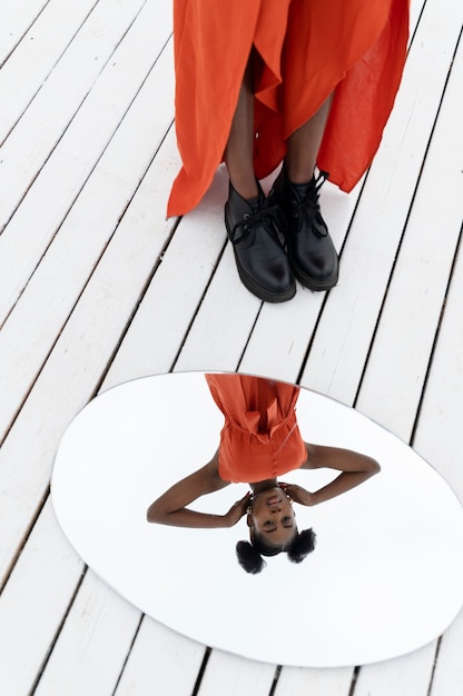 mujer joven, con, vestido rojo, posar, aire libre, con, espejo