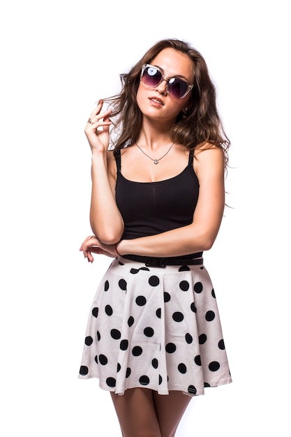 Mujer joven con un vestido de verano con gafas de sol aislado sobre fondo blanco.