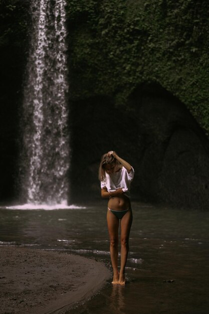 mujer joven viaja por la isla tomando fotos en una cascada