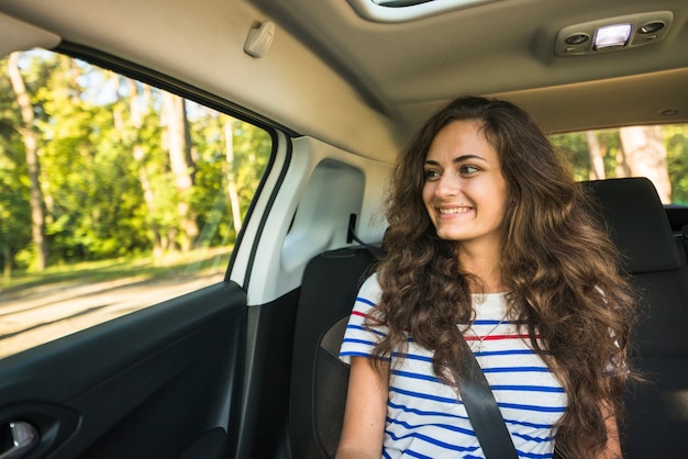 Mujer joven en un viaje por coche