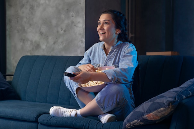 Mujer joven viendo servicio de streaming en casa