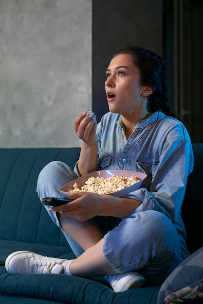 Mujer joven viendo servicio de streaming en casa