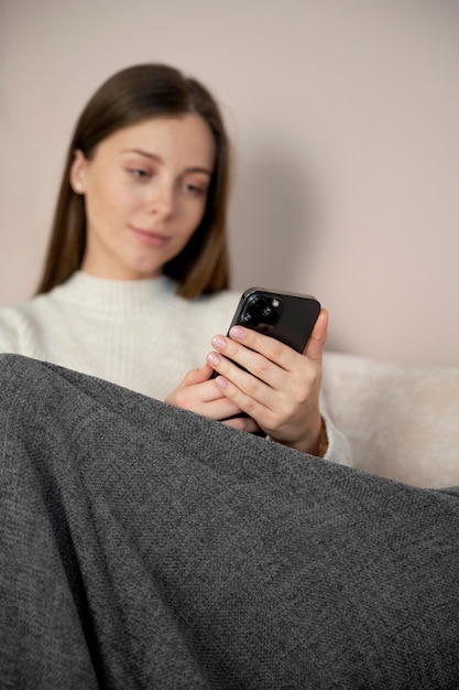 Foto gratuita mujer joven viendo un video con su teléfono inteligente