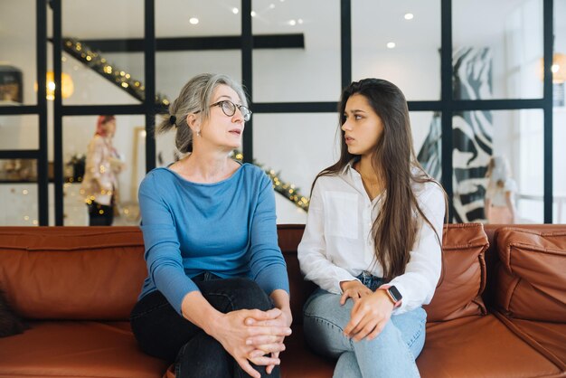 Mujer joven visitando a la abuela en casa las mujeres hablan