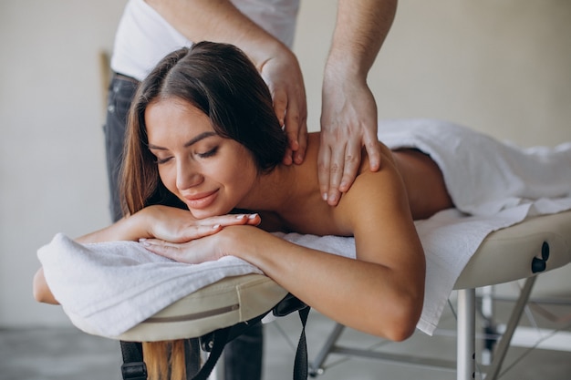 Mujer joven visitando masajista en el centro de spa