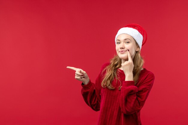 Mujer joven de vista frontal con expresión encantada, rojo de vacaciones de Navidad