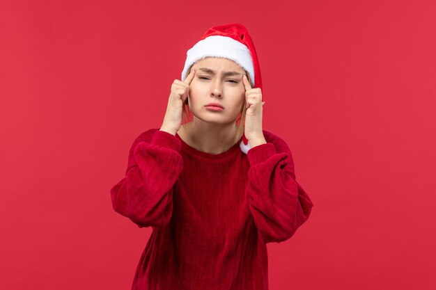 Mujer joven de vista frontal con expresión de pensamiento, Navidad roja de vacaciones