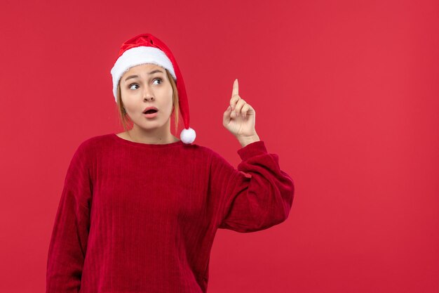 Mujer joven de vista frontal con expresión de pensamiento, Navidad roja de vacaciones